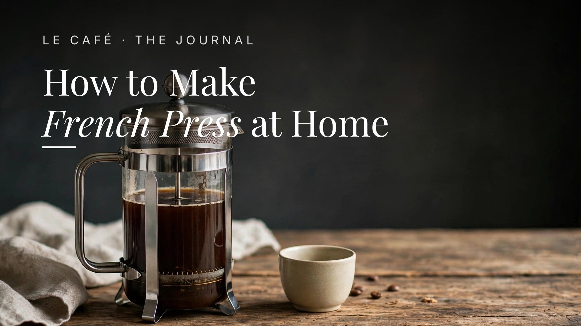 A French press on a wooden table in morning light, Le Café Journal header: How to Make French Press at Home