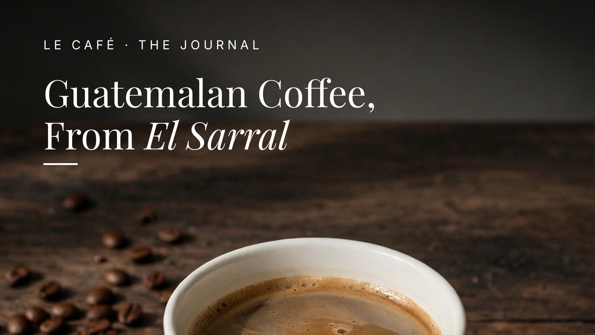 A white cup of medium roast coffee on a dark wood table in soft morning light, with whole beans nearby. Le Café Journal header: Guatemalan Coffee, From El Sarral
