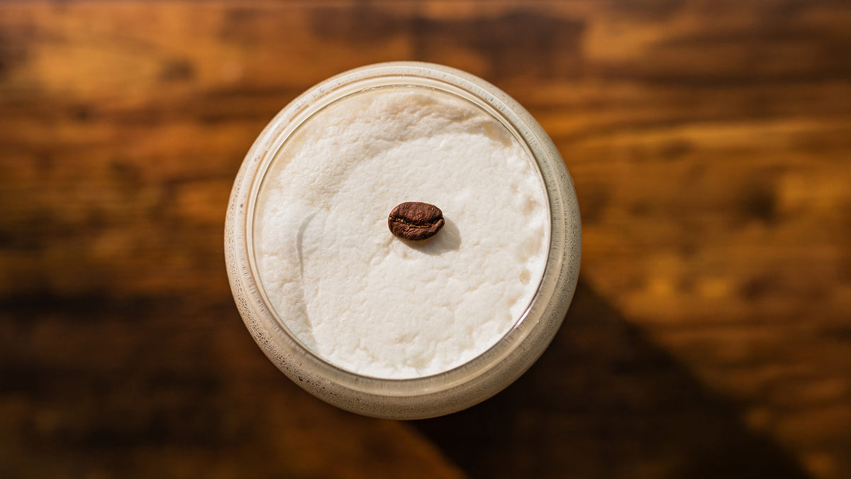 Cappuccino with a single coffee bean, top-down view